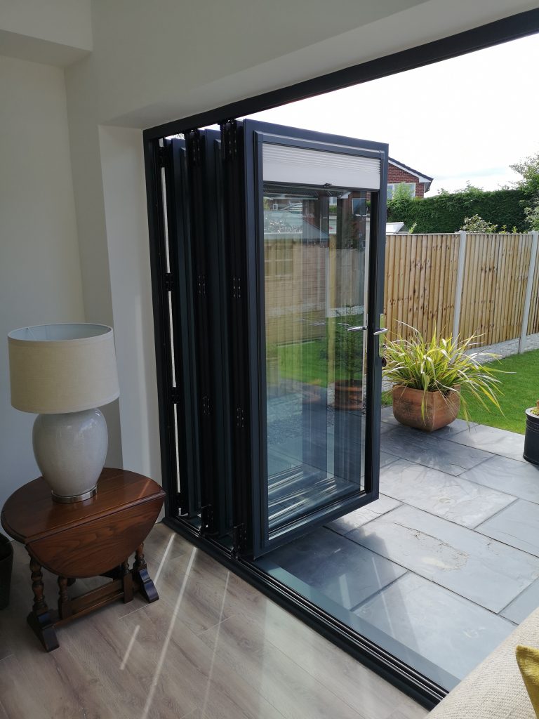 Dark grey door set into a brick elevation