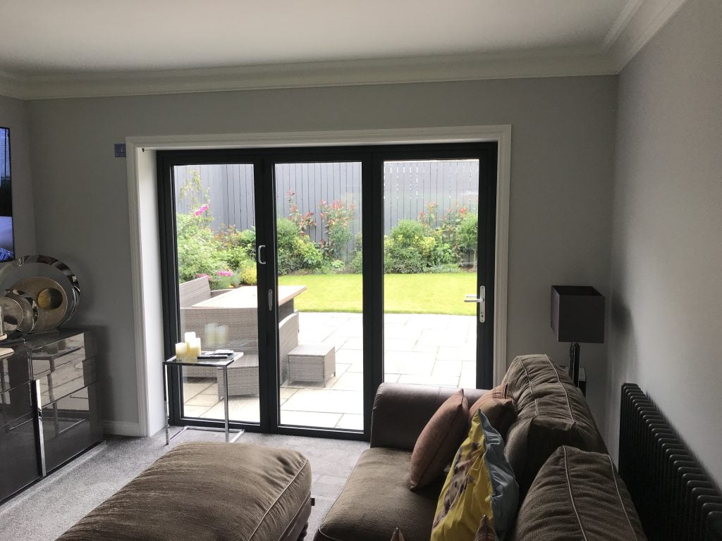 Grey bi-fold doors opening onto a paved patio