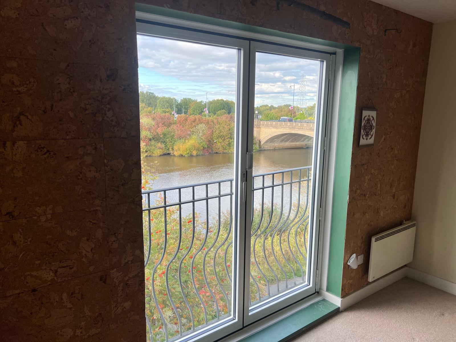 White framed patio doors with a waterside view