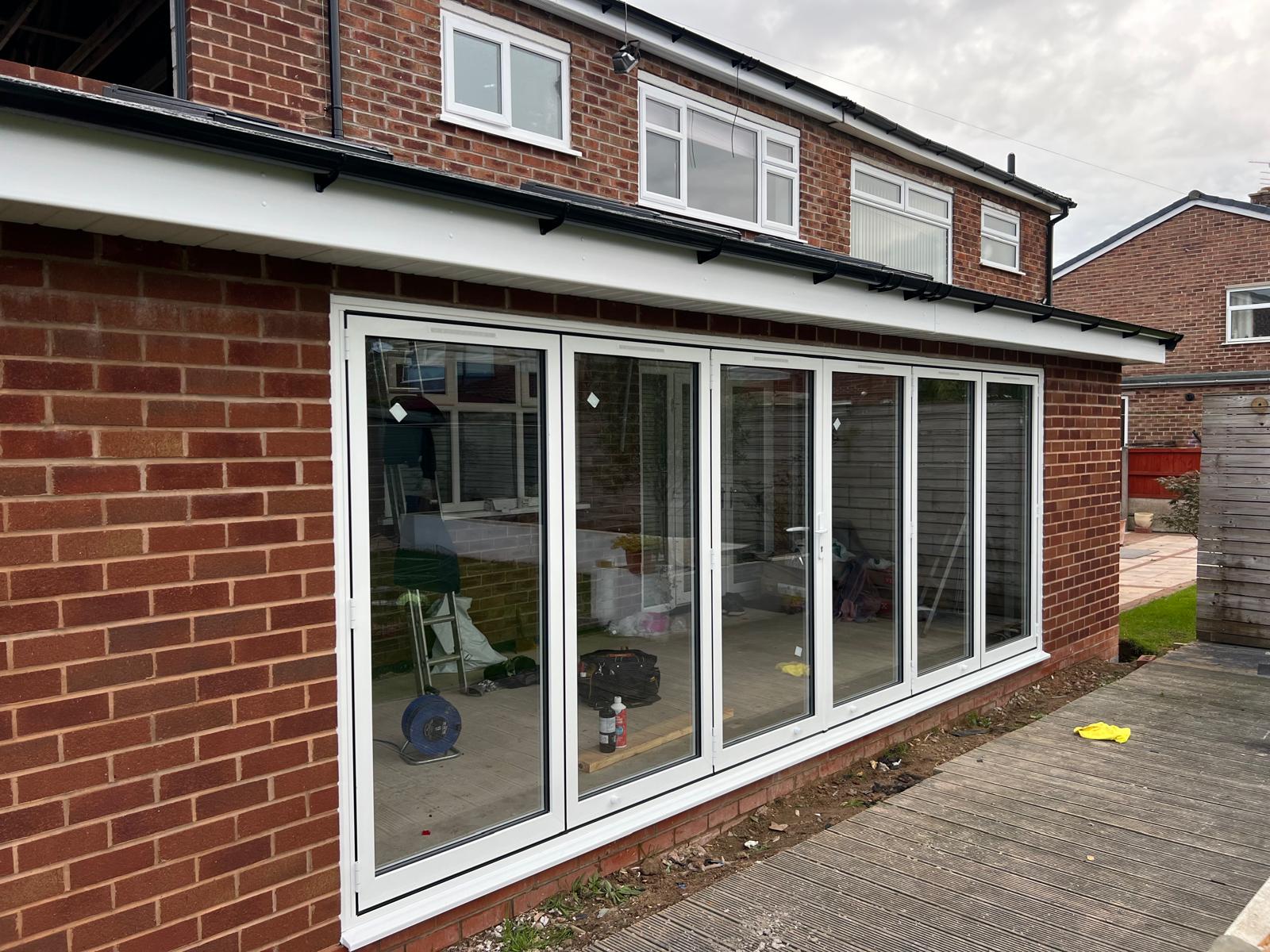 Grey framed windows and doors along a rear elevation